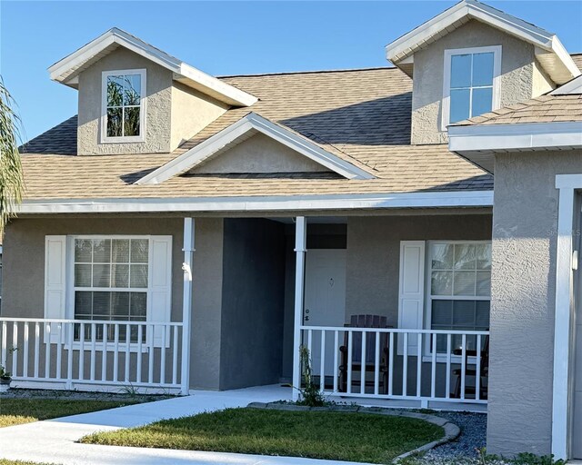 4042 Kingsfield Dr, Parrish, FL 34219 - view of front of home featuring roof with shingles, covered porch, and stucco siding