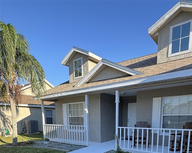 4042 Kingsfield Dr, Parrish, FL 34219 - view of front of house with covered porch, roof with shingles, central AC unit, and stucco siding