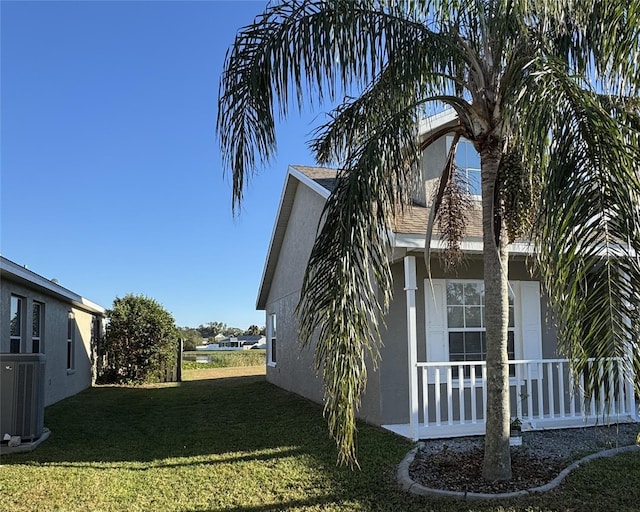 view of property exterior with central AC and a lawn