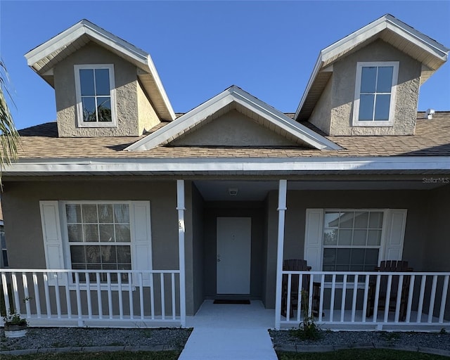4042 Kingsfield Dr, Parrish, FL 34219 - view of front of house featuring a porch, roof with shingles, and stucco siding