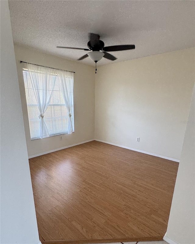 4042 Kingsfield Dr, Parrish, FL 34219 - spare room featuring a ceiling fan, wood finished floors, a textured ceiling, and baseboards