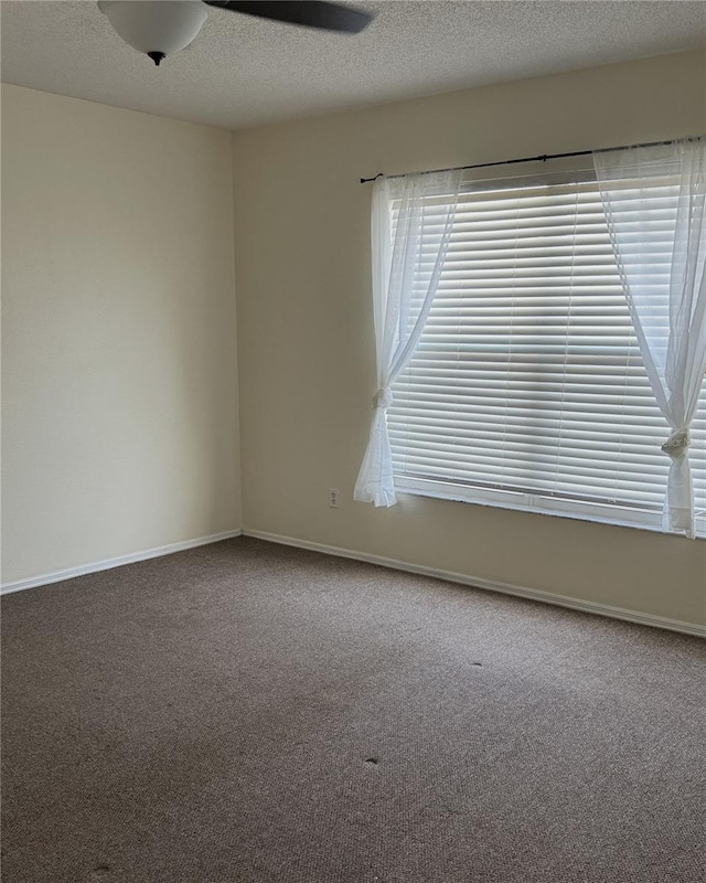 unfurnished room with ceiling fan, carpet floors, and a textured ceiling