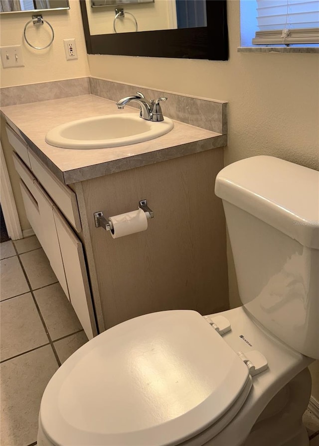 bathroom with tile patterned flooring, vanity, and toilet