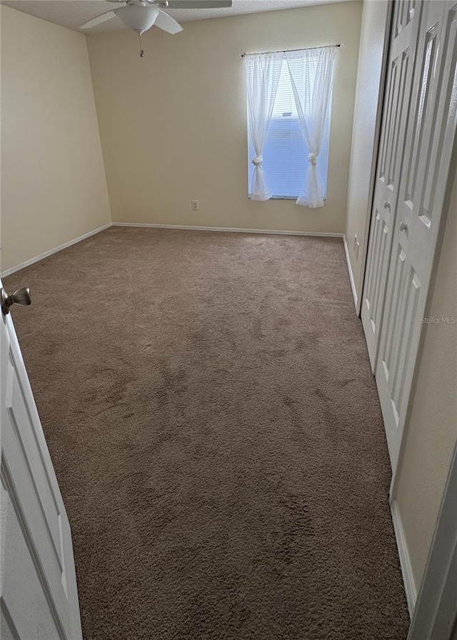 unfurnished bedroom featuring a closet, light colored carpet, and ceiling fan