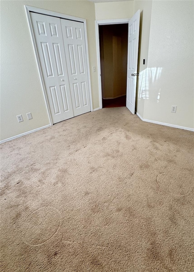 unfurnished bedroom with carpet floors and a closet