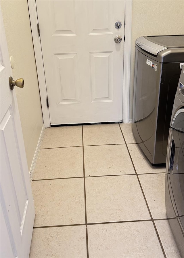 laundry room featuring light tile patterned floors and washing machine and clothes dryer