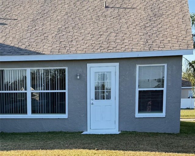 4042 Kingsfield Dr, Parrish, FL 34219 - property entrance with roof with shingles, stucco siding, and a yard