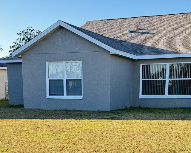 4042 Kingsfield Dr, Parrish, FL 34219 - view of property exterior featuring a yard, stucco siding, and a shingled roof