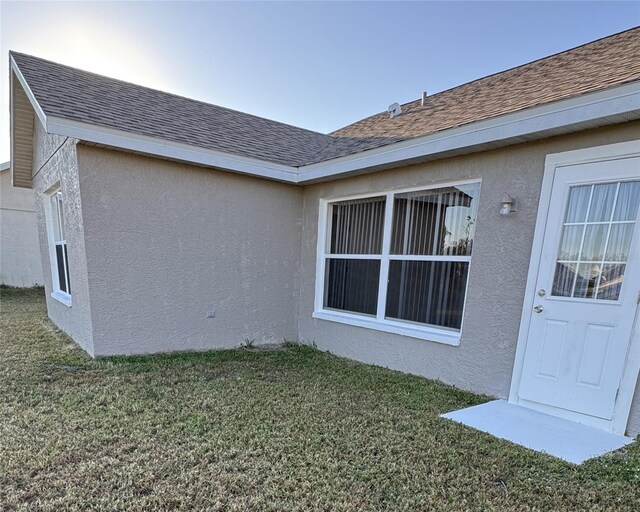 4042 Kingsfield Dr, Parrish, FL 34219 - view of side of property featuring a yard, stucco siding, and a shingled roof