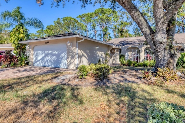 ranch-style home with a garage and a front lawn