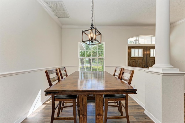 dining space with ornamental molding, dark wood-type flooring, and decorative columns