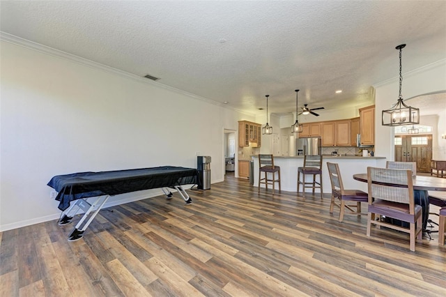 interior space featuring a textured ceiling, ceiling fan, crown molding, dark hardwood / wood-style floors, and pool table