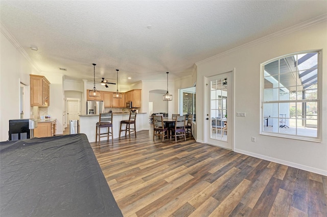 living room featuring a textured ceiling, dark hardwood / wood-style flooring, and crown molding