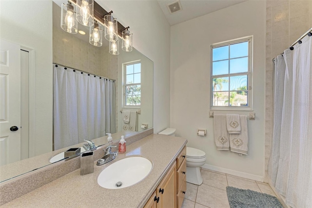 bathroom with tile patterned flooring, vanity, toilet, and walk in shower