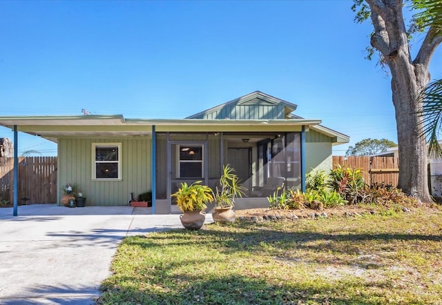 view of front of house featuring a sunroom and a front yard