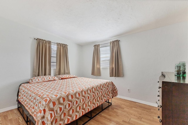 bedroom with light hardwood / wood-style flooring and multiple windows