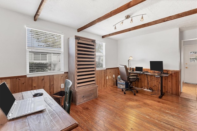 office space featuring hardwood / wood-style flooring, beam ceiling, a textured ceiling, and wooden walls