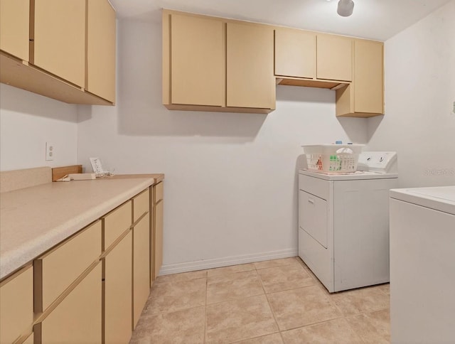 laundry area featuring cabinets, light tile patterned flooring, and washer and dryer