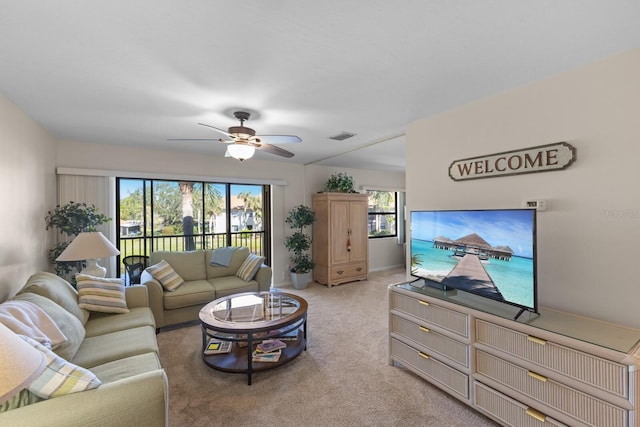 carpeted living room with ceiling fan and a healthy amount of sunlight