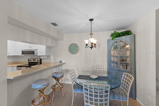 tiled dining room with an inviting chandelier