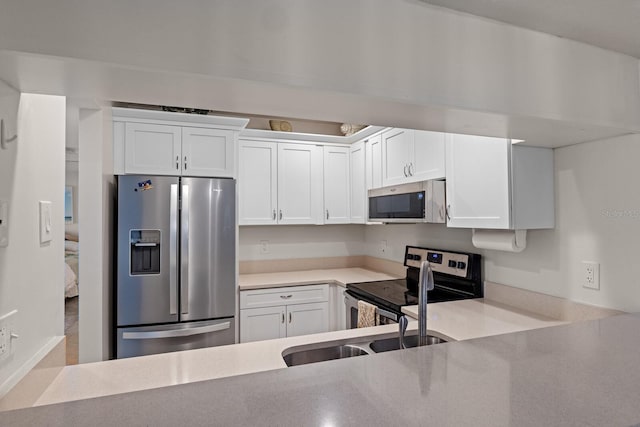 kitchen featuring white cabinets, stainless steel appliances, and sink