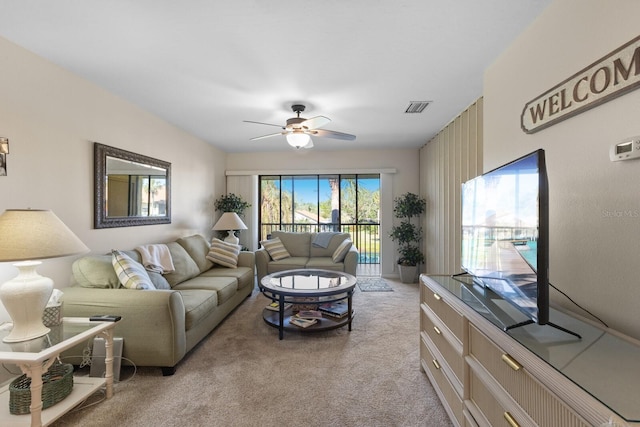 carpeted living room with ceiling fan