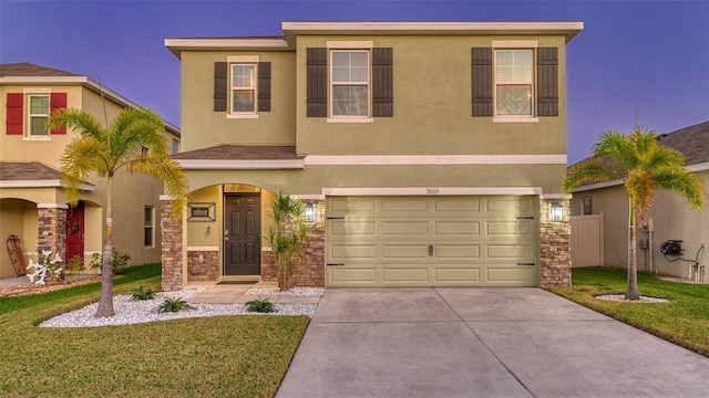 view of front facade with a garage, stone siding, driveway, stucco siding, and a front yard