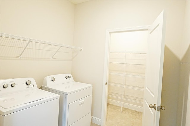 clothes washing area with independent washer and dryer and light tile patterned floors