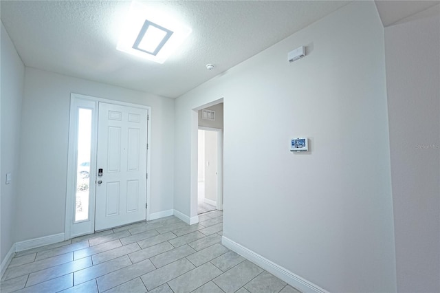 tiled entrance foyer featuring a textured ceiling