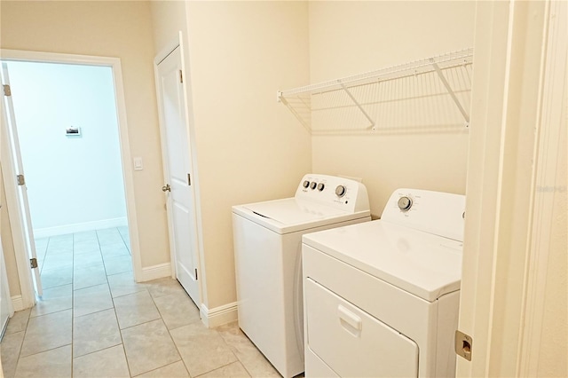 laundry area with light tile patterned floors and washing machine and clothes dryer