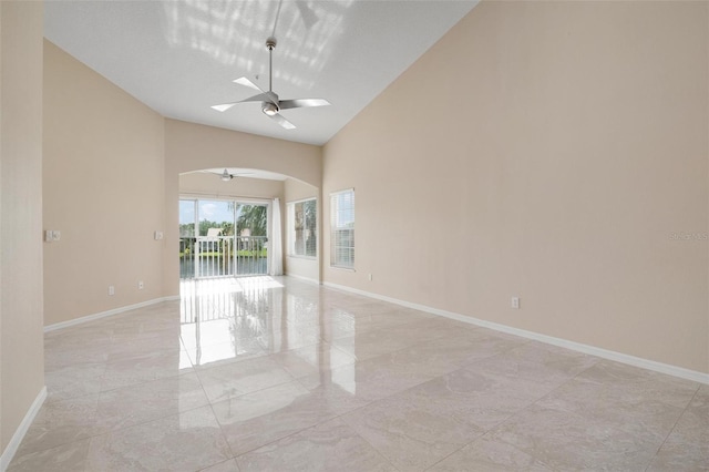 unfurnished room with ceiling fan and high vaulted ceiling