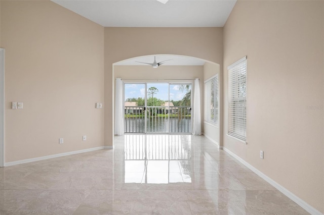 unfurnished room featuring a water view and ceiling fan