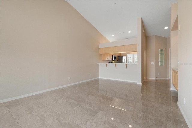 unfurnished living room with high vaulted ceiling