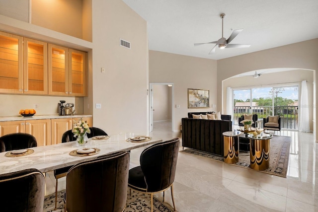 kitchen with a kitchen breakfast bar, ceiling fan, and a high ceiling