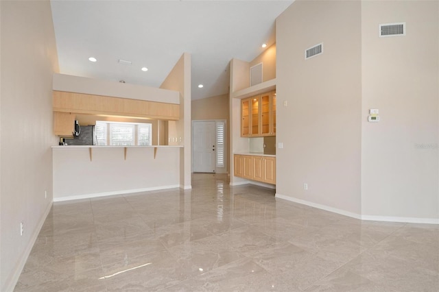 unfurnished living room featuring high vaulted ceiling