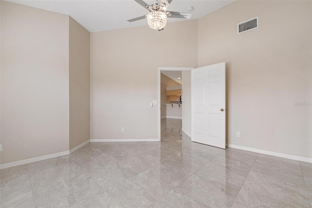 spare room with ceiling fan and a high ceiling