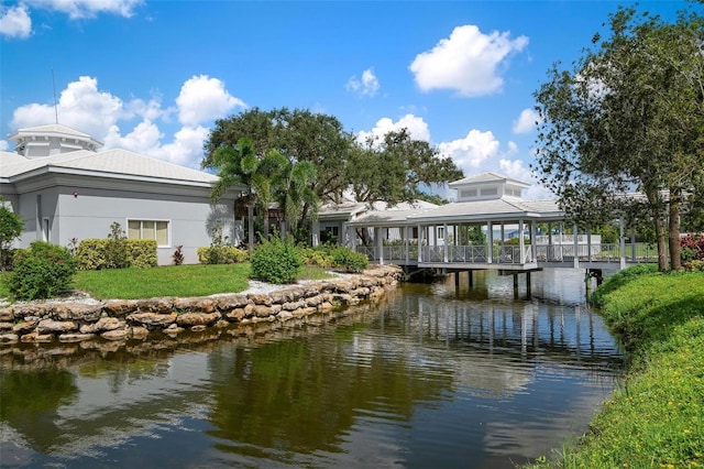 view of dock with a lawn and a water view