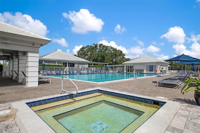 view of swimming pool featuring a patio and a hot tub