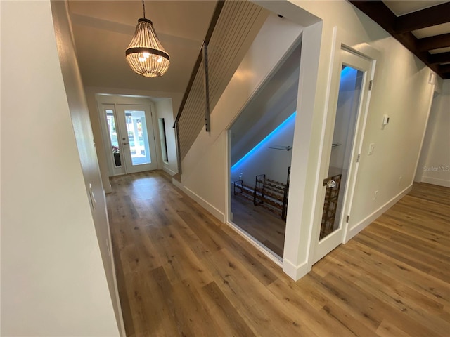 hall with a notable chandelier and hardwood / wood-style flooring