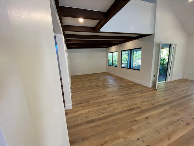 interior space with vaulted ceiling with beams and wood-type flooring