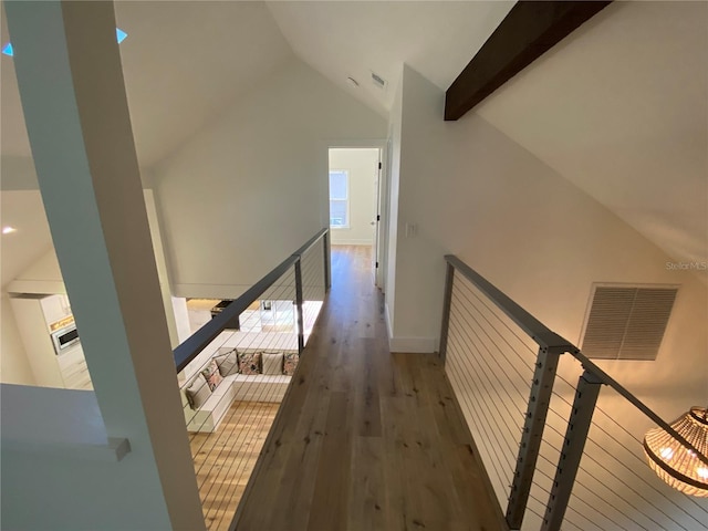 hall with beam ceiling, high vaulted ceiling, and dark hardwood / wood-style floors