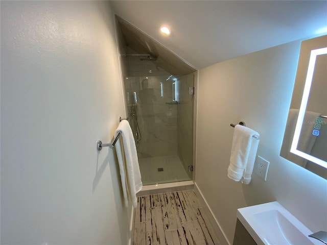 bathroom with vanity, walk in shower, and vaulted ceiling