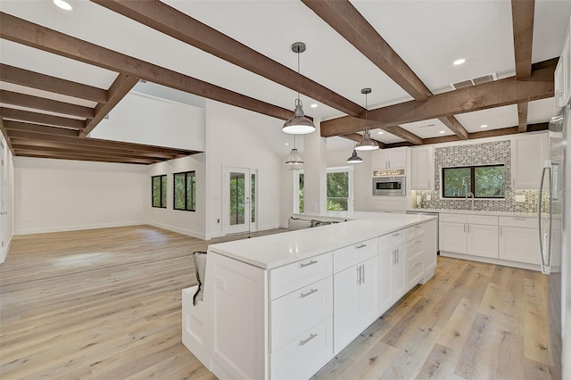 kitchen featuring pendant lighting, backsplash, white cabinets, and light wood-type flooring