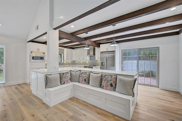 living room featuring beamed ceiling and light hardwood / wood-style flooring