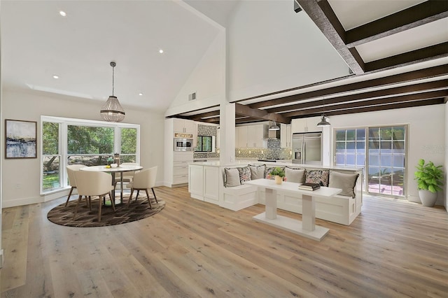 living room featuring beamed ceiling, high vaulted ceiling, and light hardwood / wood-style floors