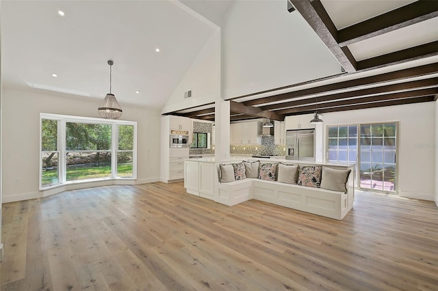 unfurnished living room featuring beam ceiling, high vaulted ceiling, and light hardwood / wood-style flooring