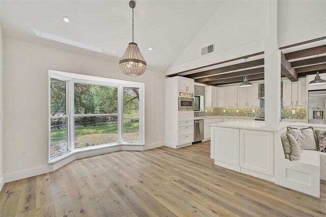 kitchen featuring stainless steel appliances, tasteful backsplash, white cabinets, decorative light fixtures, and light wood-type flooring