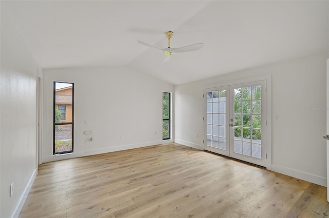 spare room with vaulted ceiling, a wealth of natural light, light wood-type flooring, and french doors