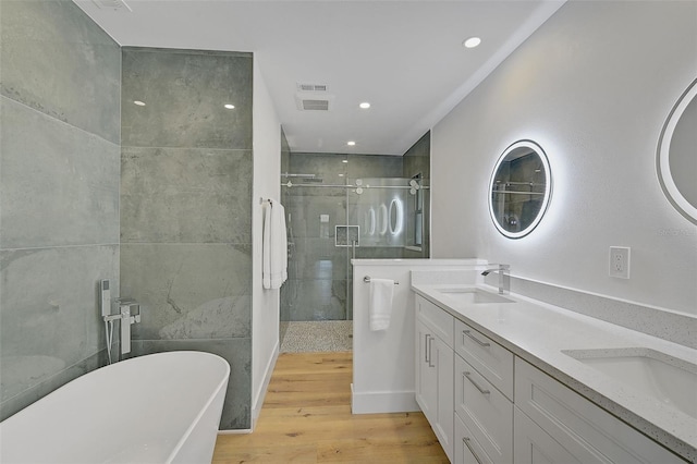 bathroom featuring wood-type flooring, independent shower and bath, and vanity