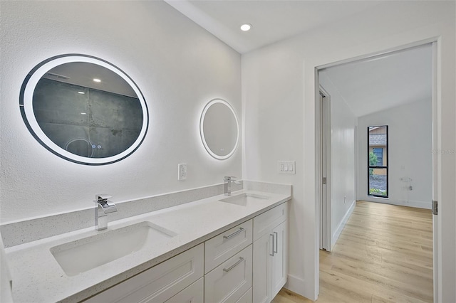 bathroom with vanity, hardwood / wood-style flooring, and lofted ceiling